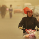 A woman wears a plastic bag over her head in Shanxi province.